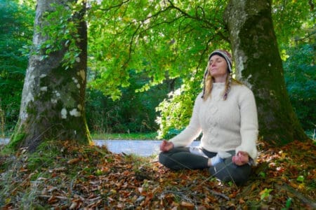 Winnie Bothe meditating under a tree in the Yogi Living Retreat garden, cultivating inner force, peace, balance, and wisdom.